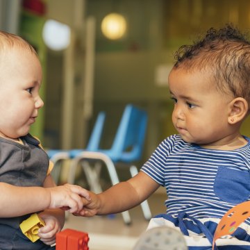 babies playing holding hands baby monitors